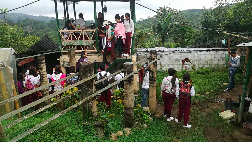A photo showing students standing on and amongst structures on a farm with lush rolling green hills in the background.